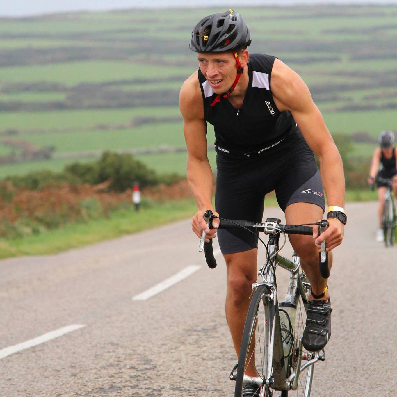 Cornwall roofing company owner Adam rides his bike uphill on a Cornish road.